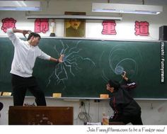 two people standing in front of a blackboard with writing on it