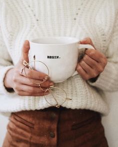 a woman holding a coffee cup with her hands