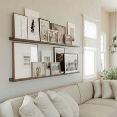 a living room filled with lots of furniture and pictures on the wall above it's couch