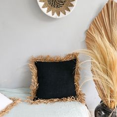 a black and white pillow sitting on top of a bed next to a wall clock