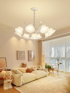 a living room filled with furniture and a chandelier hanging from the ceiling above it