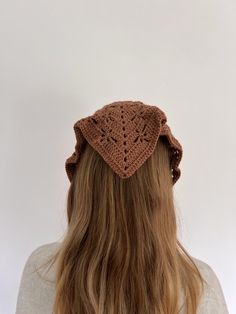 the back of a woman's head wearing a crocheted hat with long hair