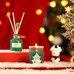 a christmas scene with candles and ornaments on the floor next to a small christmas tree