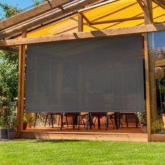 an outdoor covered patio with table and chairs under a yellow awning that is partially closed