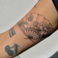 a woman with a tattoo on her arm holding an umbrella and flowers in the background