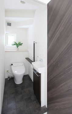 a white toilet sitting next to a sink in a bathroom