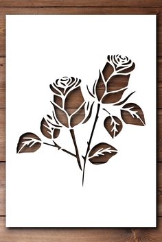 a paper cutout of three roses on a wooden surface