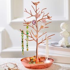 a tree that is sitting on top of a table next to some beads and other items