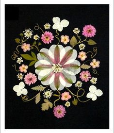 an embroidered flower design on a black background with pink and white flowers in the center