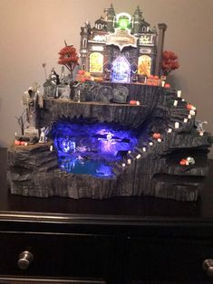 a fake waterfall in the corner of a room with halloween decorations on it and an illuminated fountain