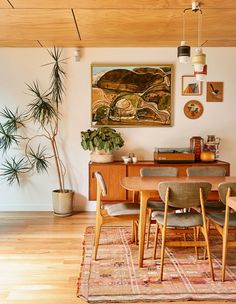 a dining room table with chairs and a painting on the wall