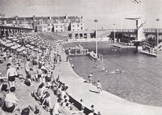 an old black and white photo of people on the beach