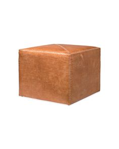 a brown leather ottoman sitting on top of a white floor