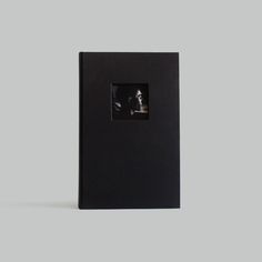 a black book with a man's face in the middle and an image of a person behind it