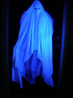 a ghostly ghost hanging in the dark with blue light coming from it's mouth