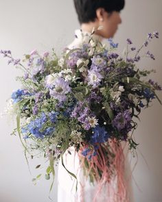 a woman holding a bouquet of flowers in her hands