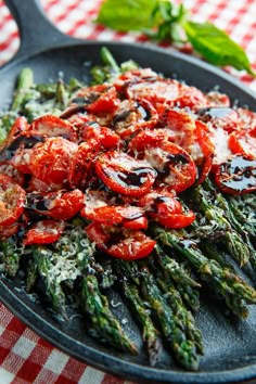 asparagus with tomatoes and parmesan cheese in a cast iron skillet