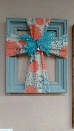 a blue frame with a bow hanging on the wall