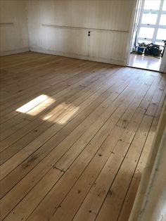 an empty room with wood floors and white walls