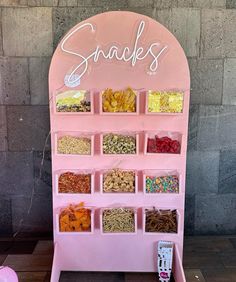 a pink snack stand with snacks on it