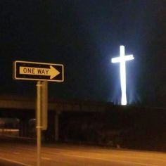 a street sign with a large cross in the background