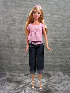 the doll is wearing jeans and a pink shirt