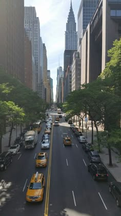 taxi cabs are lined up on the street in front of tall buildings and skyscrapers