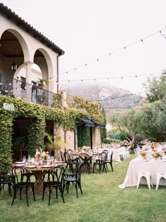 an outdoor dining area with tables and chairs set up for a formal function in the grass