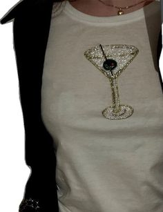 a woman wearing a white t - shirt with a martini glass on the front and black sleeves