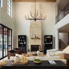 a living room filled with lots of furniture and a chandelier hanging from the ceiling