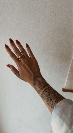 a woman's arm and hand with tattoos on it