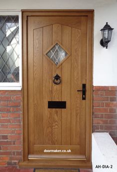 a wooden door is shown in front of a brick wall and light fixture on the side