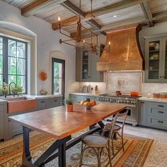 a large kitchen with an island table in the middle