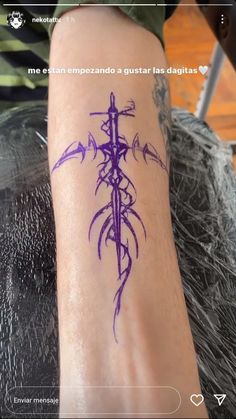 a person with a tattoo on their arm that is purple and has an arrow in the middle