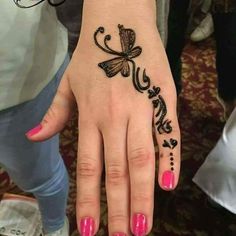 a woman's hand with a butterfly tattoo on it