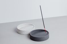 a white and grey object with a red stick sticking out of it's center