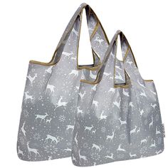 two gray bags with white deers on them, one has gold handles and the other has silver handles