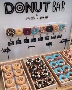 an assortment of doughnuts on display at a donut bar