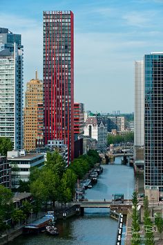 there are many tall buildings along the river in this cityscape with boats on the water