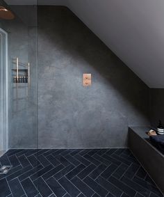 a bathroom with a walk in shower next to a bathtub and sink under a slanted ceiling