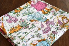 a close up of a cloth on a wooden surface with animals and cats all over it