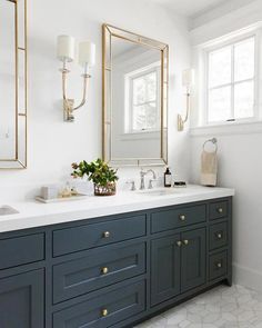 a bathroom with two sinks and large mirrors on the wall next to eachother