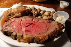 a roast beef on a plate with potatoes and carrots