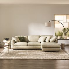 a living room with a couch, chair and lamp on the floor in front of a window