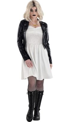 a woman in a white dress and black leather jacket is posing for the camera with her hands on her hips