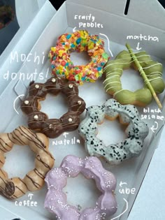 four donuts in a box with different toppings and words written on the side