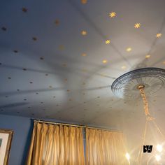 the ceiling is decorated with gold stars and white drapes, along with a chandelier