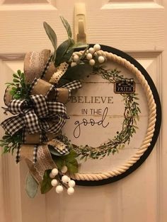 a wreath that says believe in the good written on it, hanging on a door