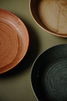 two brown and black bowls sitting next to each other