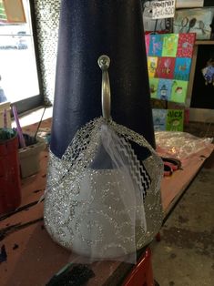 a hat with a veil on it sitting on top of a table next to a lamp